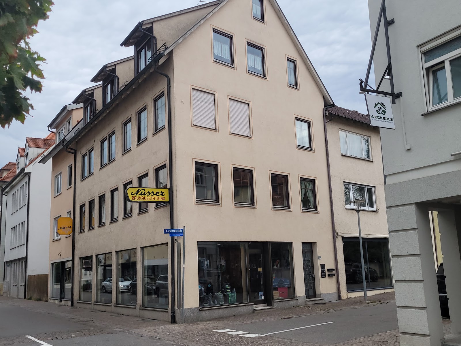 Werkstatt von Nusser Raumausstattung an der Ecke Mittlere Straße/Charlottenstraße in Mengen, mit dem gelben Firmenschild